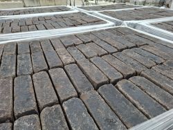 Altgebrannter Pflasterstein im Dickformat, Anthrazit, auf Paletten.