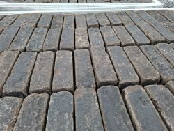 Altgebrannter Pflasterstein im Dickformat, Anthrazit, auf Paletten.